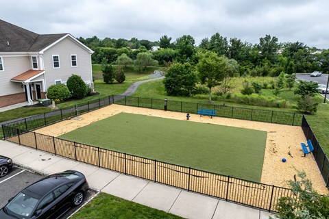 A black car is parked in a driveway next to a house.