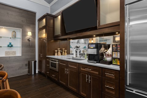 A modern kitchen with dark wood cabinets and stainless steel appliances.