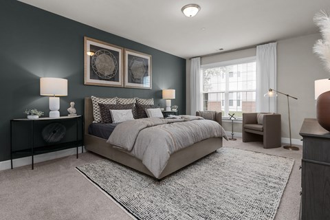 A bedroom with a large bed and a window with curtains.