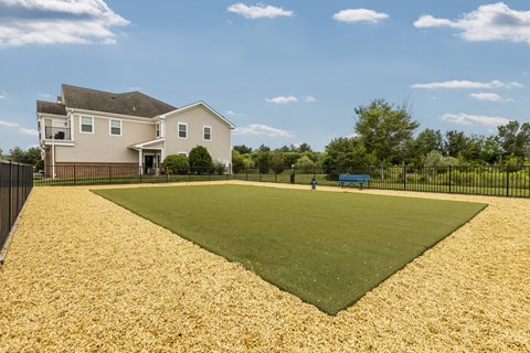 A house with a large yard and a blue bench.