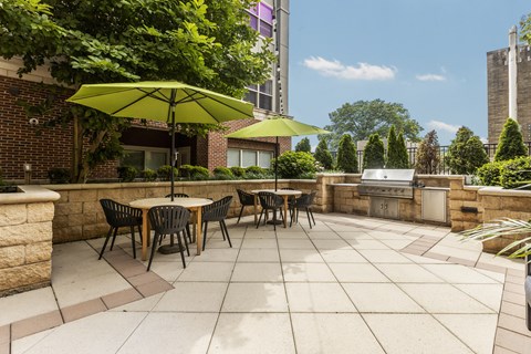 A patio with a table and chairs under a green umbrella.
