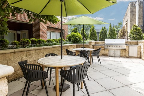 A patio with a table and chairs under a green umbrella.