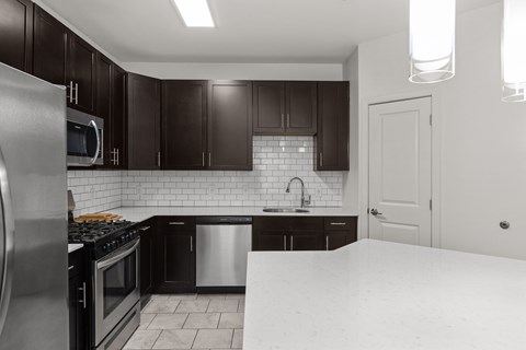 A kitchen with black cabinets and a white countertop.
