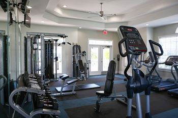 a gym with various cardio machines and weights at Champions Walk Apartment Homes, Bradenton, 34210