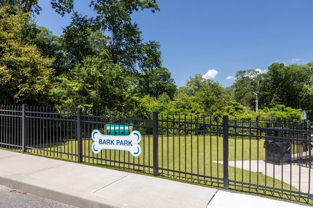 A sign that says Bark Park is on a black fence.