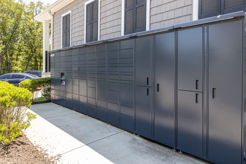 A long grey storage unit is on a concrete slab.