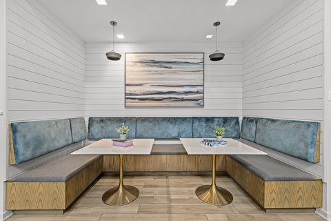 A modern dining area with a wooden table and blue cushioned booths.