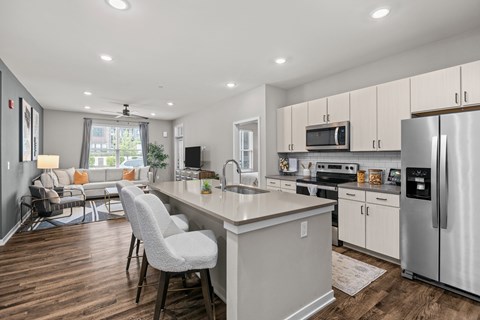 A modern kitchen with a large island and stainless steel appliances.