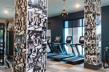 a fitness room with treadmills and weights and a curtain of exercise equipment at The Yards at Malvern, Pennsylvania