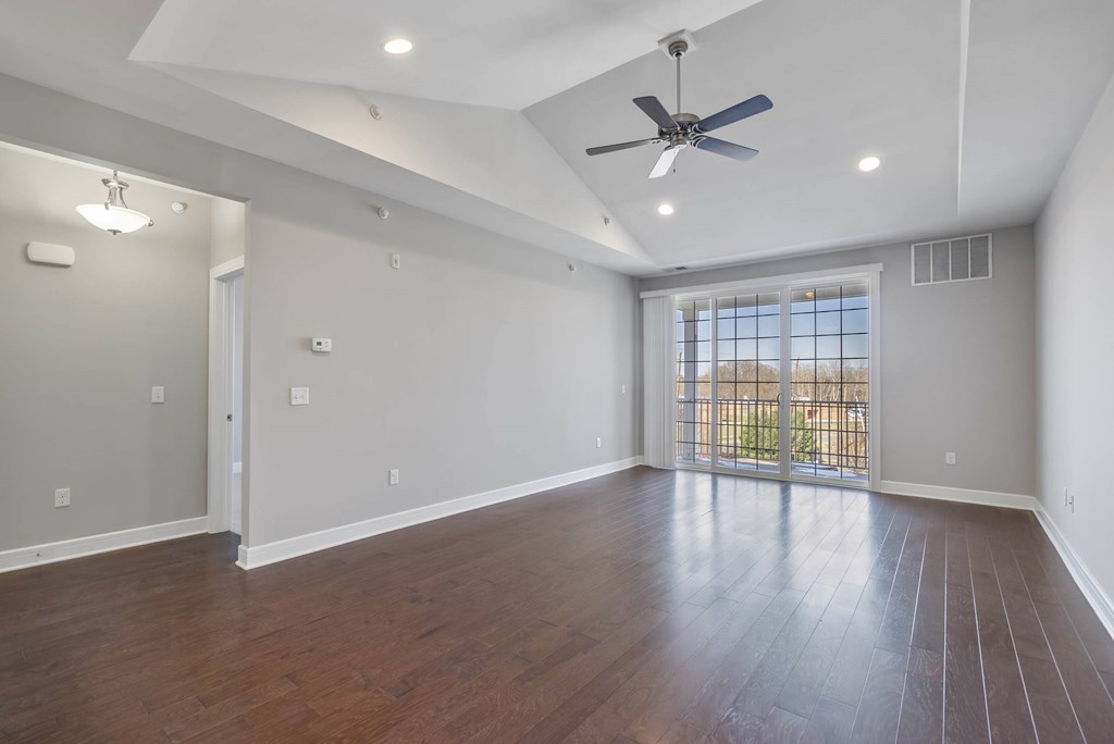 A spacious room with a ceiling fan and wooden flooring. A spacious room with a ceiling fan and wooden flooring. at Pennsauken Golf Course Villas, PENNSAUKEN