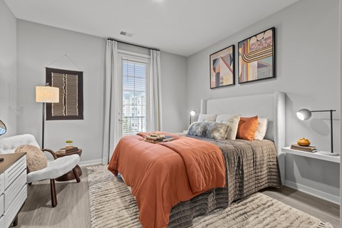 A bedroom with a large bed and a chair.