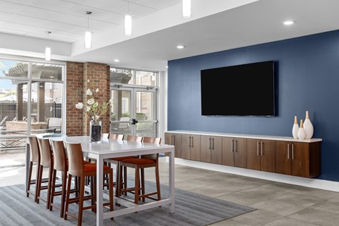 A modern dining room with a large table and chairs.