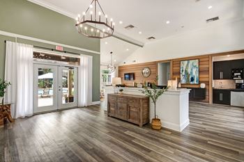 a living room with a kitchen and a chandelier at Timberwalk at Mandarin Apartment Homes, Florida, 32257