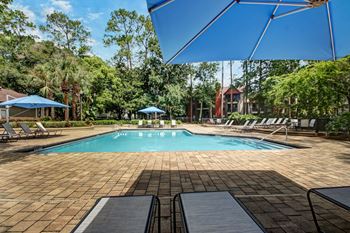 a swimming pool with chairs and umbrellas at the resort at Timberwalk at Mandarin Apartment Homes, Florida, 32257