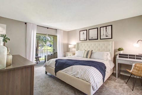 Bedroom with bed and lamp at The Fountains at Deerwood Apartments, Jacksonville