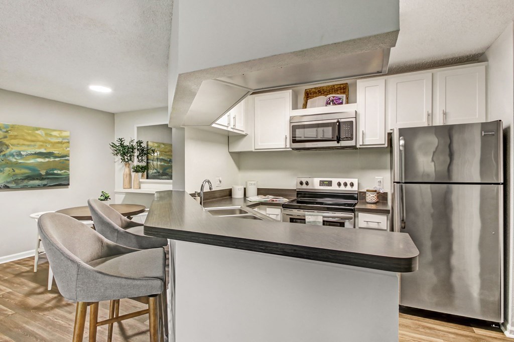 a kitchen a kitchen with stainless steel appliances and a counter with chairs at Timberwalk at Mandarin Apartment Homes, Florida, 32257