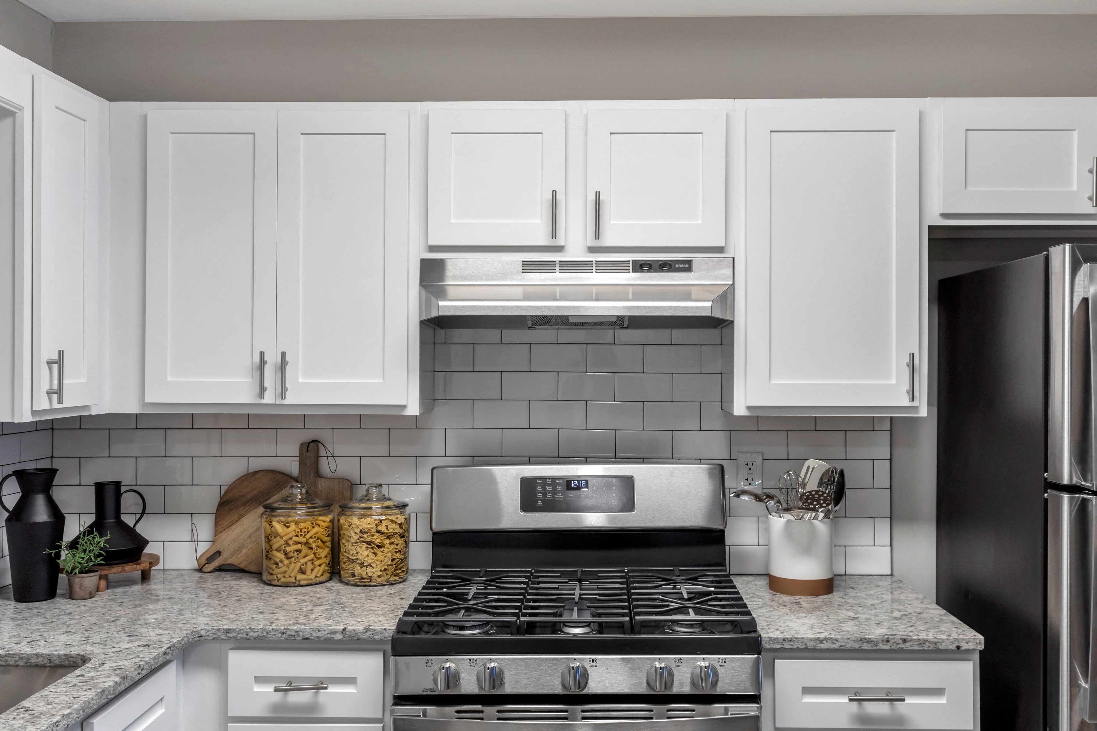 a white kitchen with stainless steel appliances and white cabinets