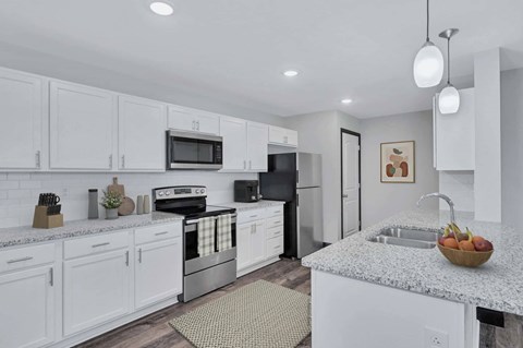 A modern kitchen with white cabinets and a granite countertop.