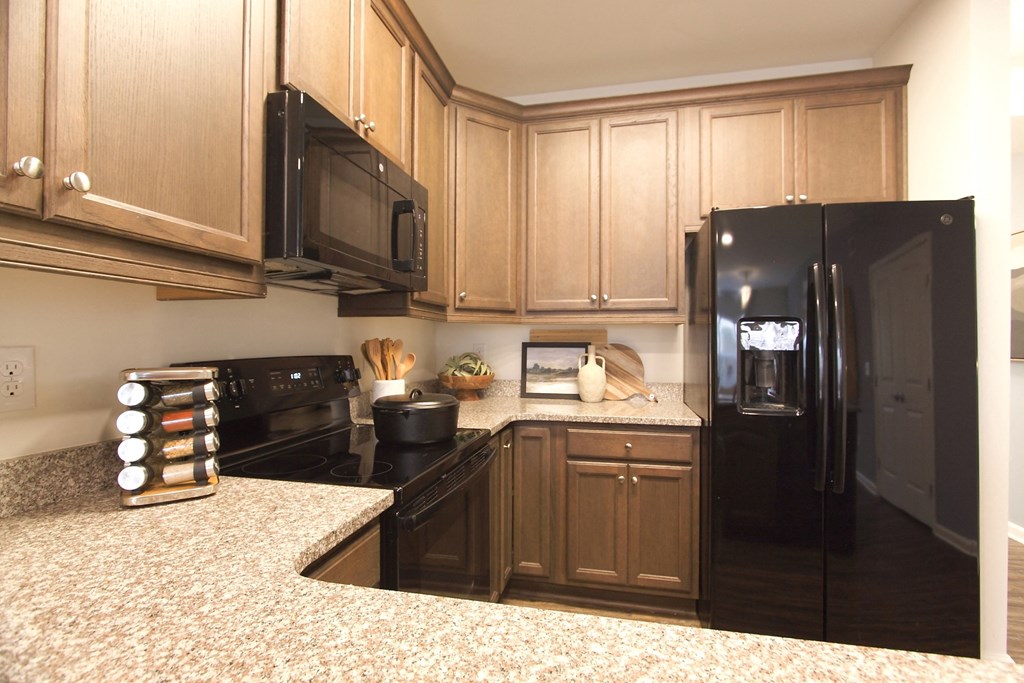 a kitchen with black appliances and wood cabinets  at Carillon Woods, Delaware, 19966