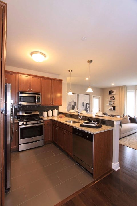 A kitchen with wooden cabinets and stainless steel appliances  at Barclay Glen Apartments, Williamstown, NJ, 08094