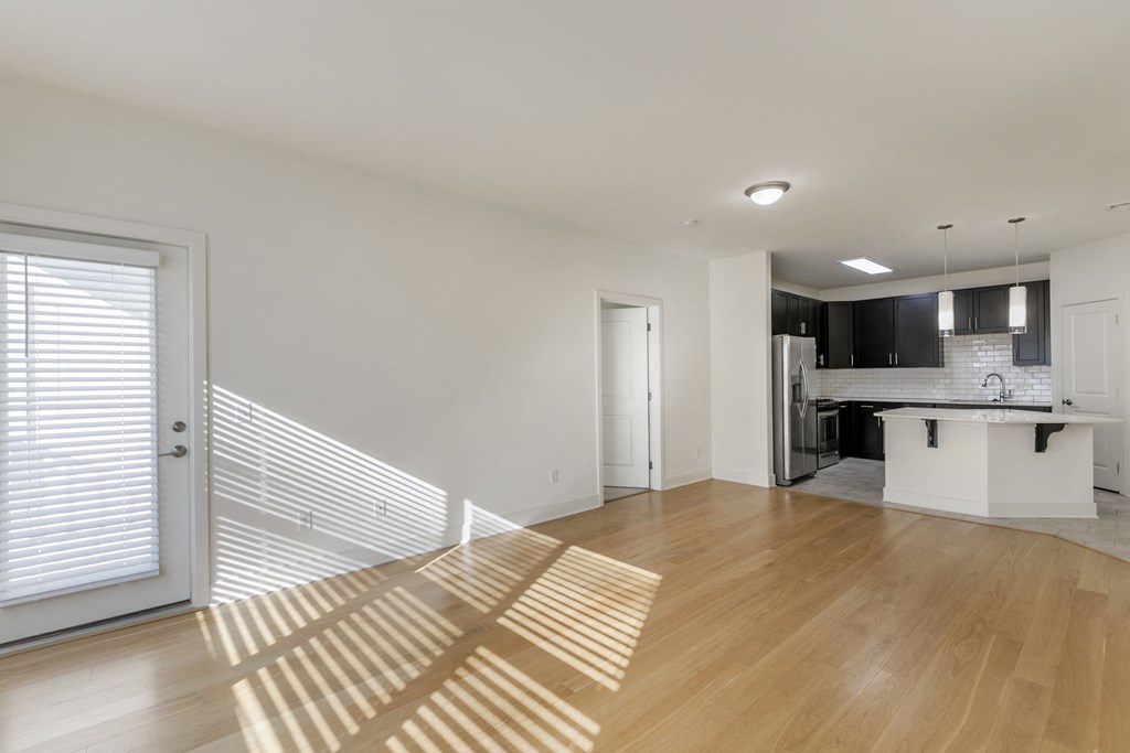 a living room and kitchen with a sliding glass door  at The Collings at the Lumberyard, Collingswood, NJ