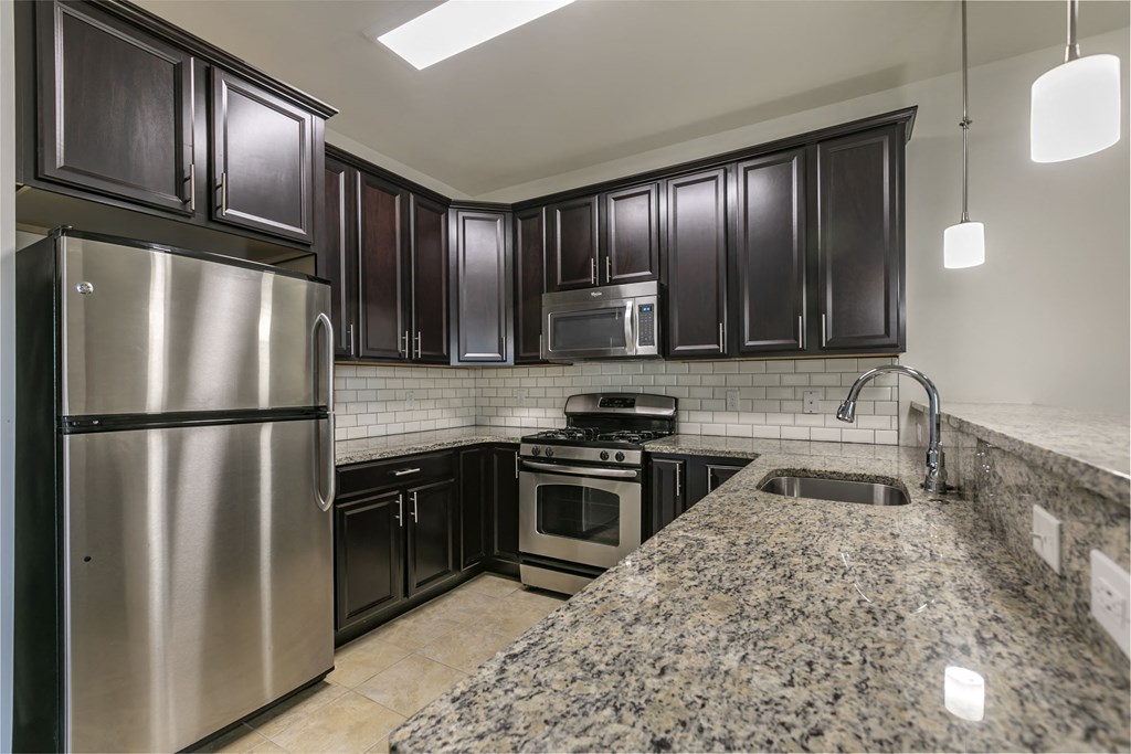 a kitchen with stainless steel appliances and granite counter tops at The Collings at the Lumberyard, Collingswood, 08108