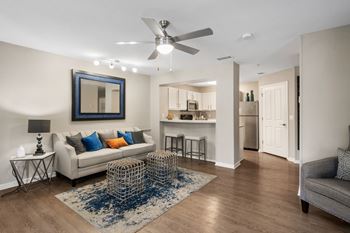 a living room with a couch and a ceiling fan at The Monroe Apartment Homes, Tallahassee, 32303