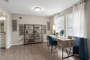 our apartments offer a spacious living room with a desk and a window at The Monroe Apartment Homes, Tallahassee, Florida