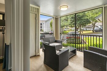 a patio with chairs and a table on a balcony at The Monroe Apartment Homes, Tallahassee, 32303