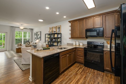 A kitchen with wooden cabinets and black appliances.