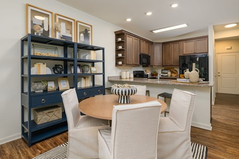 A kitchen with a dining table and chairs.