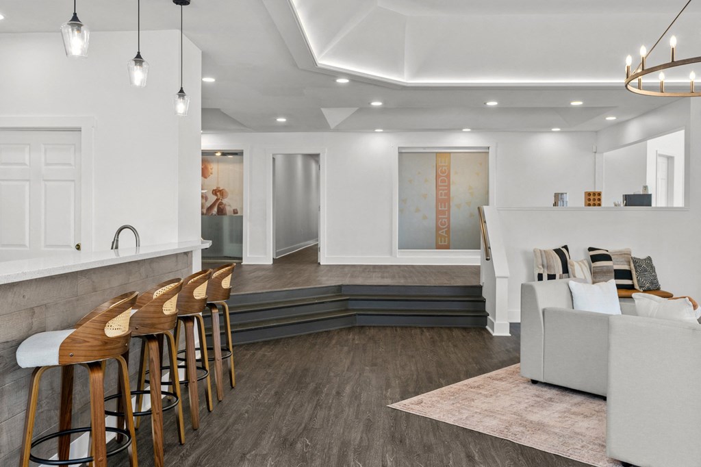 A modern living room with a bar area and a grey sofa. at Eagle Ridge Apartments, Monroeville, Pennsylvania