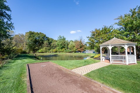 a gazebo on the side of a pond