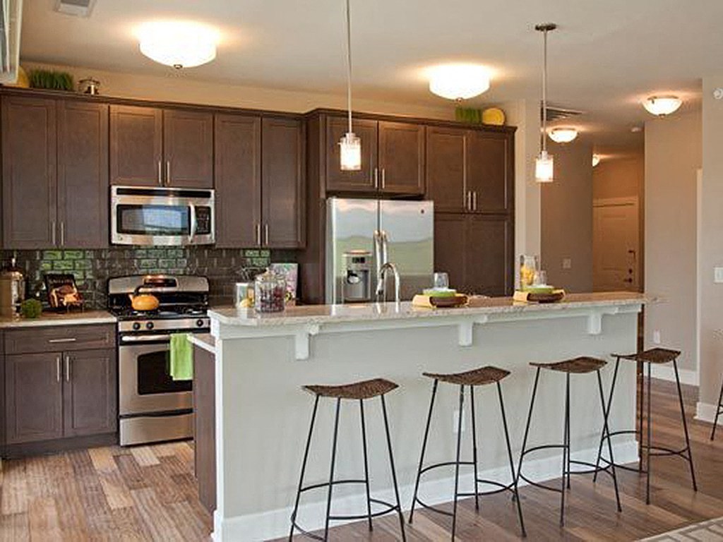 a kitchen with a counter and three bar stools