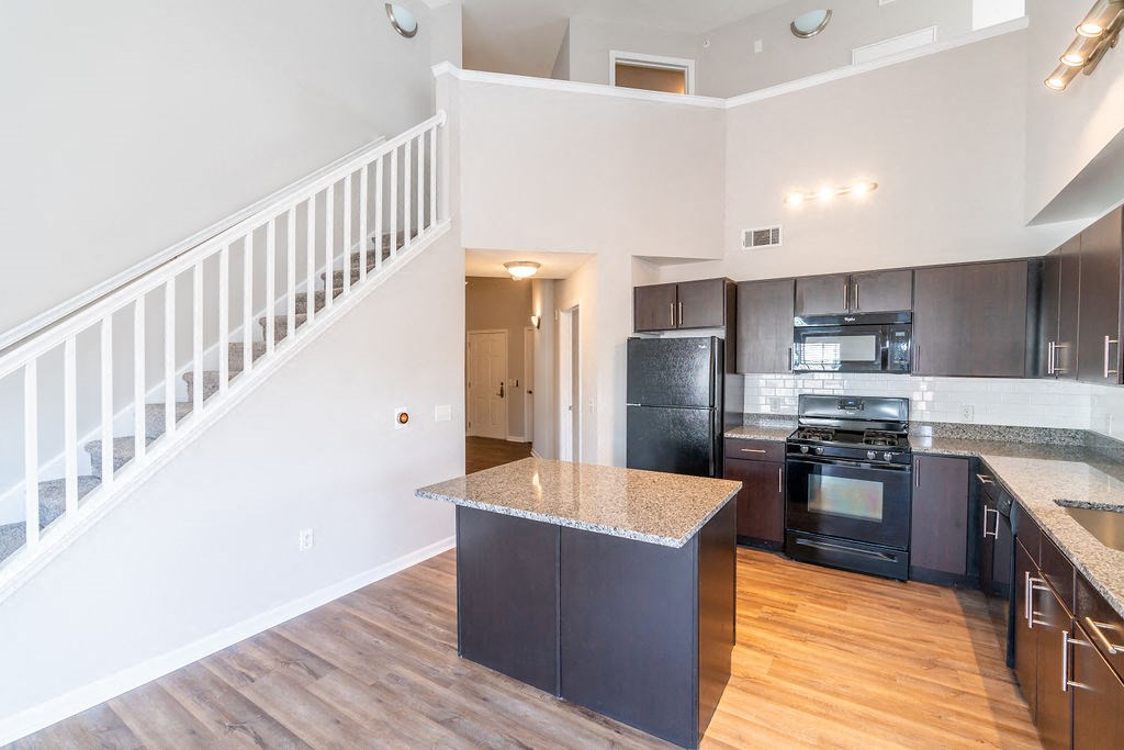 a kitchen with a counter top and a staircase  at Merion Riverwalk Apartment Homes, Shelton, 06484