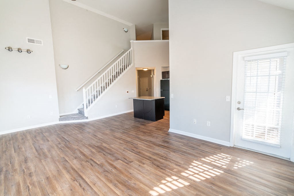 an empty living room with wood floors and a staircase at Merion Riverwalk Apartment Homes, Connecticut