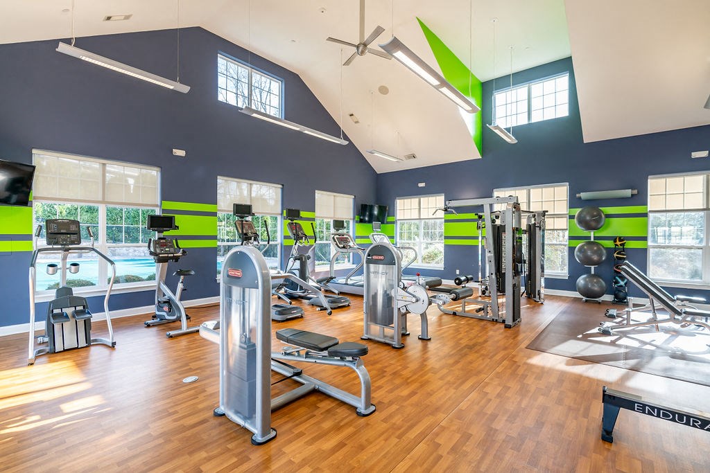 a gym with weights and cardio equipment and windows at Merion Stratford Apartment Homes, Stratford, CT, 06614