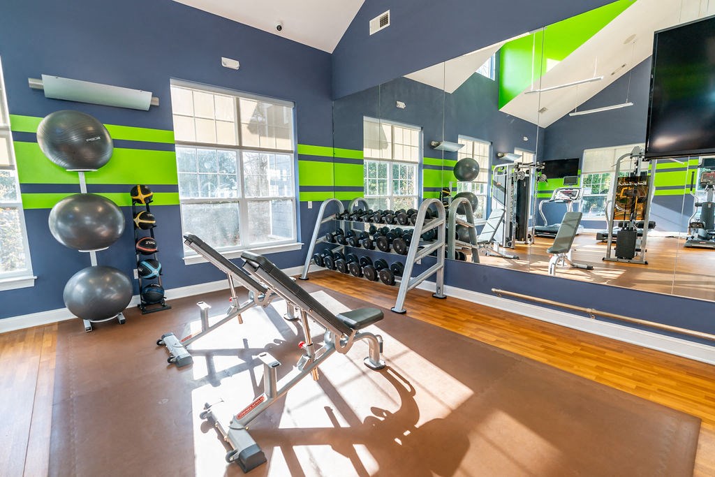 a gym with weights and a tv and windows at Merion Stratford Apartment Homes, Stratford