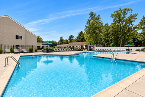 A large swimming pool with a building in the background.