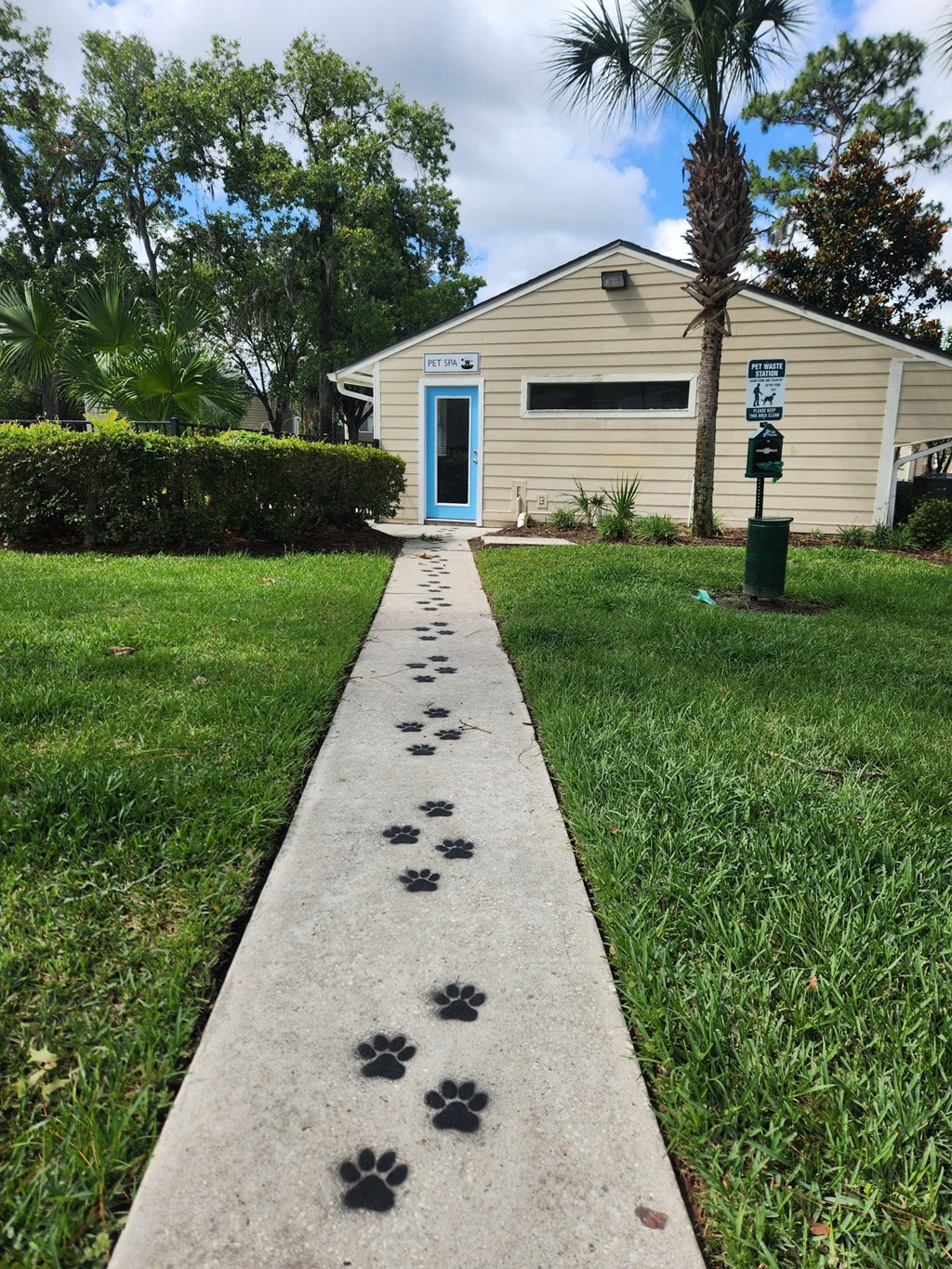 a walkway leading to a Dog Spa with paw prints on the sidewalk at The Fountains at Deerwood, Jacksonville, FL, 32256
