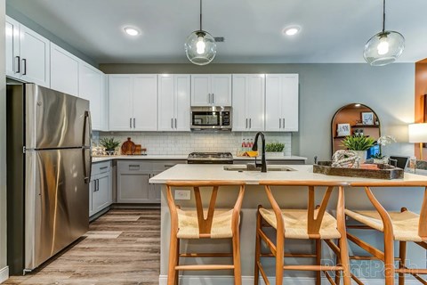 A modern kitchen with a wooden table and chairs.