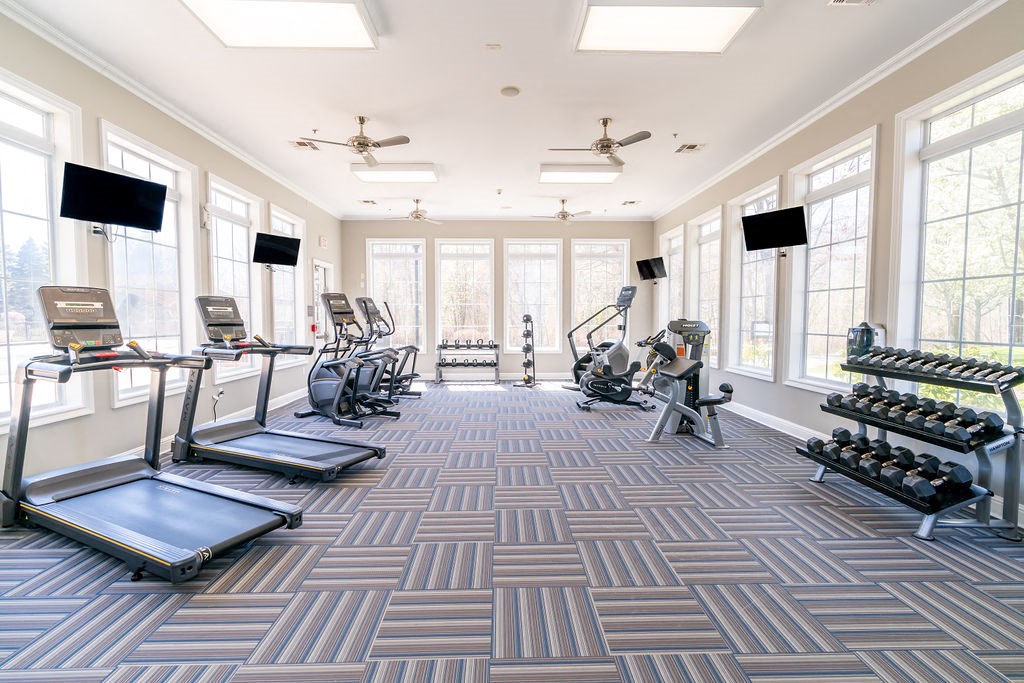 a large fitness gym with cardio machines and windows at The Ledges Apartment Homes, Groton, CT, 06340