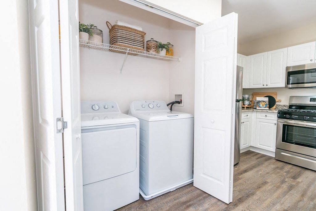 a washer and dryer in a kitchen with white cabinets at The Ledges Apartment Homes, Groton, CT, 06340
