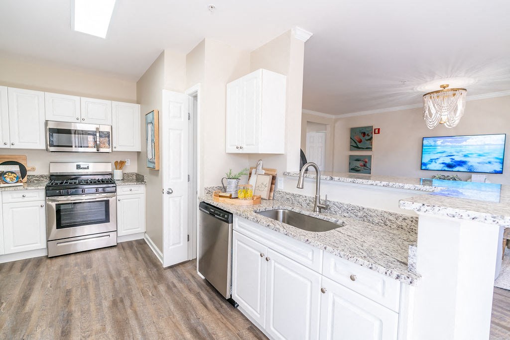 a kitchen with white cabinets and granite counter tops and stainless steel appliances at The Ledges Apartment Homes, Groton, CT, 06340