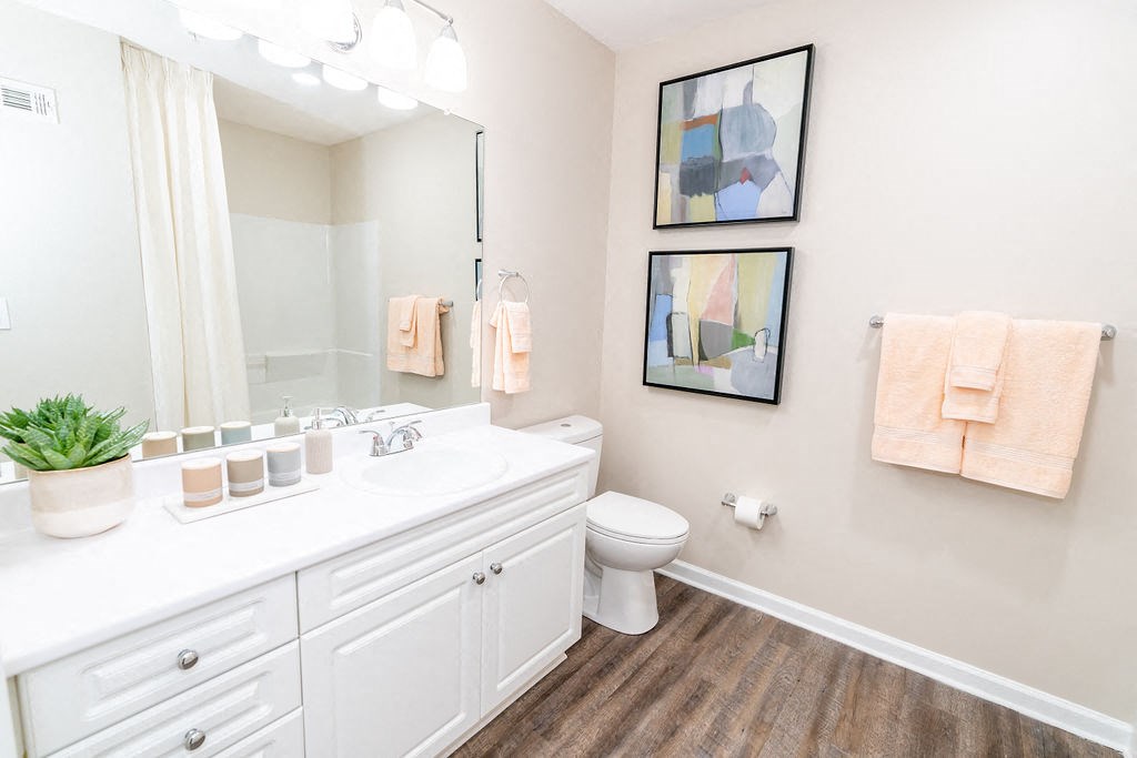a bathroom with a sink and a toilet and a mirror at The Ledges Apartment Homes, Groton, CT, 06340
