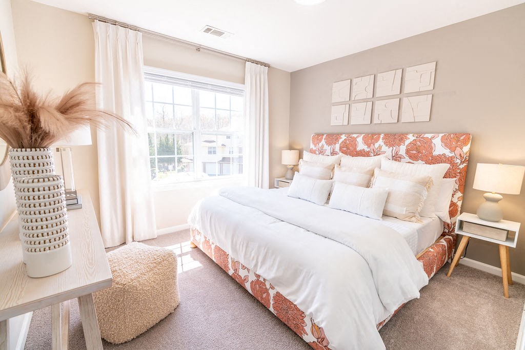 a bedroom with a large bed and a window at The Ledges Apartment Homes, Groton, CT, 06340