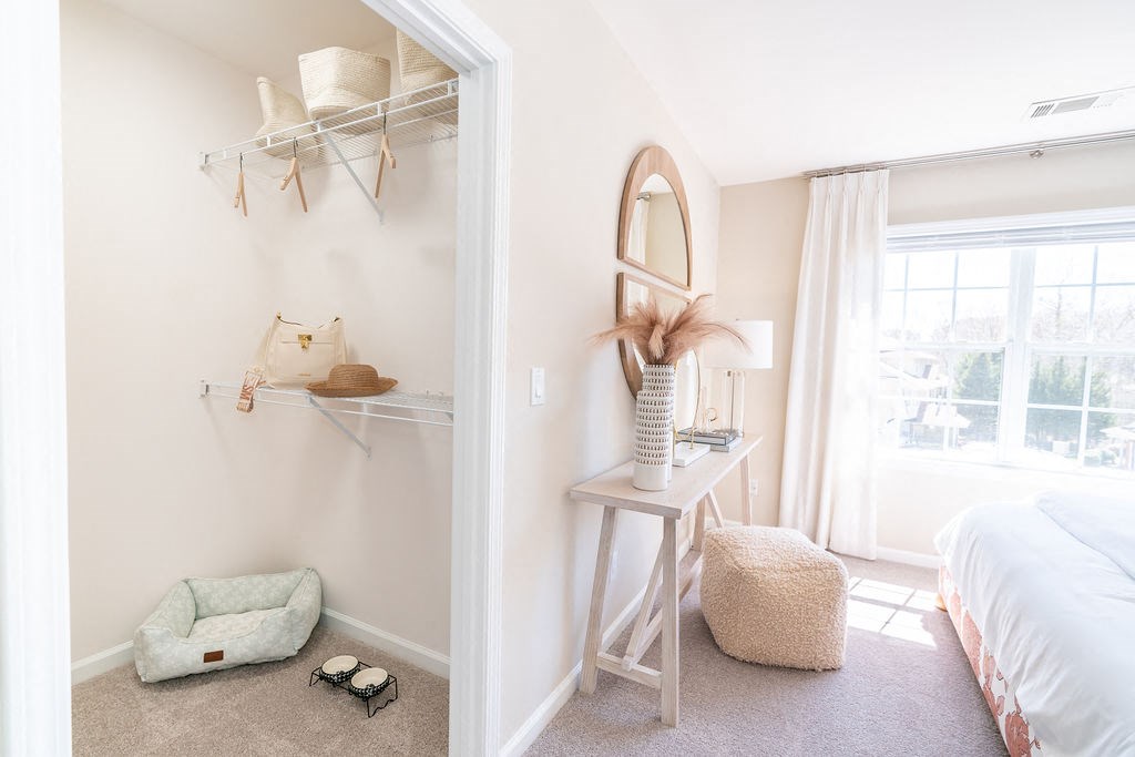 a bedroom with a mirror and a closet with a bed and a window at The Ledges Apartment Homes, Groton, CT, 06340
