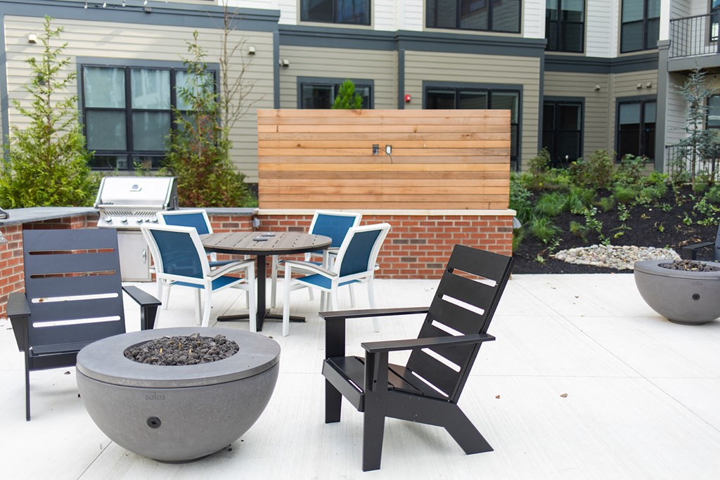 an outdoor patio with chairs and tables and a fire pit at The Yards at Malvern, Malvern, PA