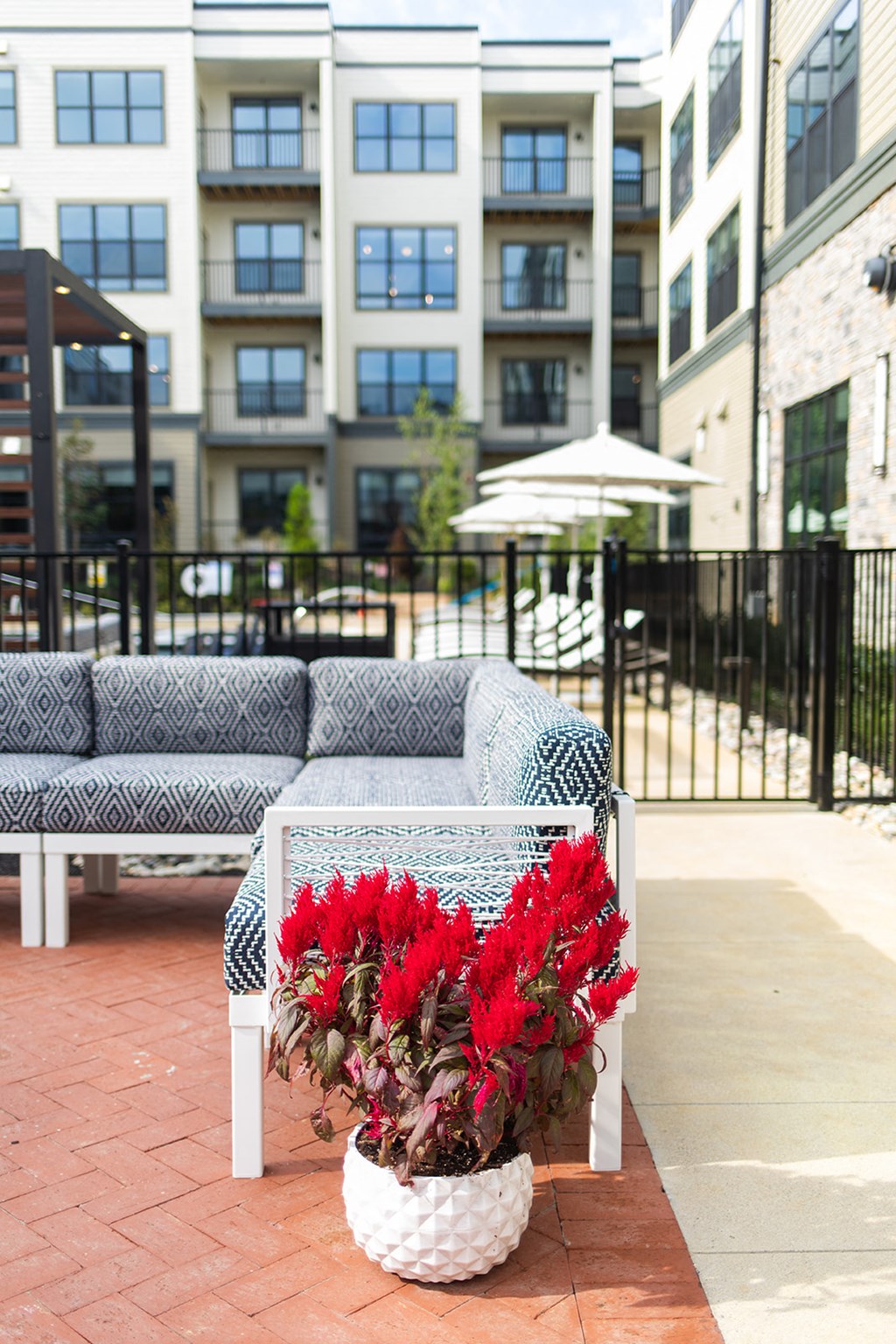 a patio with a couch and a vase of red flowers at The Yards at Malvern, Malvern, PA
