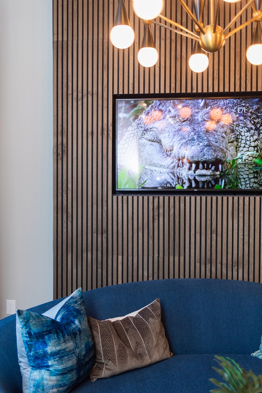 a living room with a blue couch and a tv on the wall at The Yards at Malvern, Malvern, PA